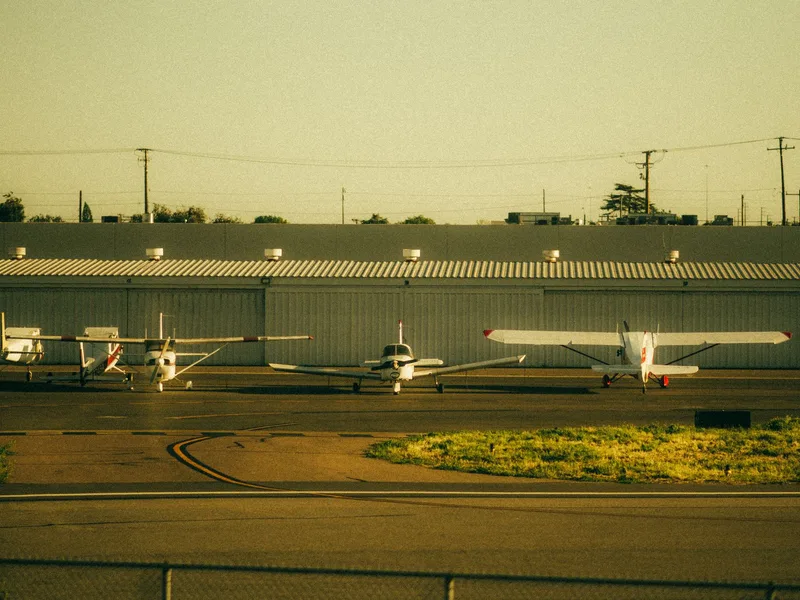 Light aircraft tied down on a ramp at sunset